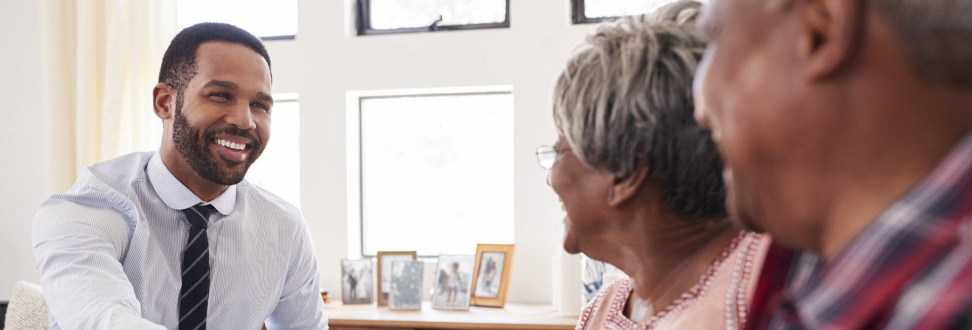 male doctor talking with senior couple smiling